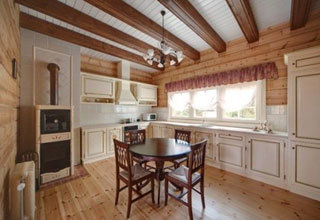 مطبخ على طراز بروفانس مع أرضيات خشبية وأسقف ذات عوارض خشبية.