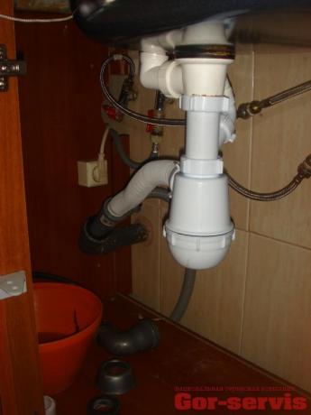 التنظيم الصحيح لزاوية التصريف من السيفون إلى أنبوب الصرف الصحي ، مصنوع باستخدام خرطوم مموج
